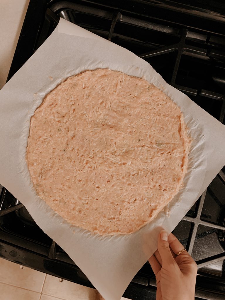 Placing the chicken crust pizza in the oven.