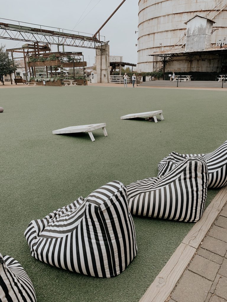 A field with corn hole and chairs